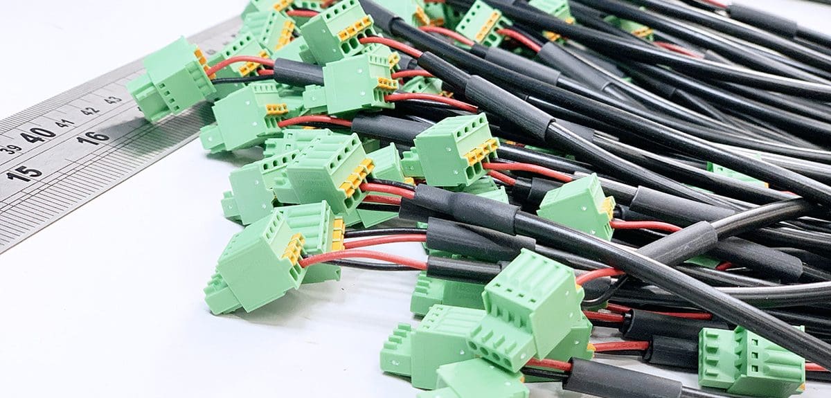 A group of wires with connectors on a white electronics work bench