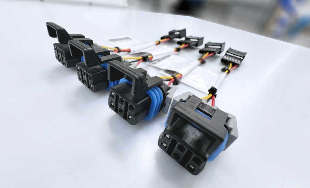 A row of electrical connectors and short wire assemblies.