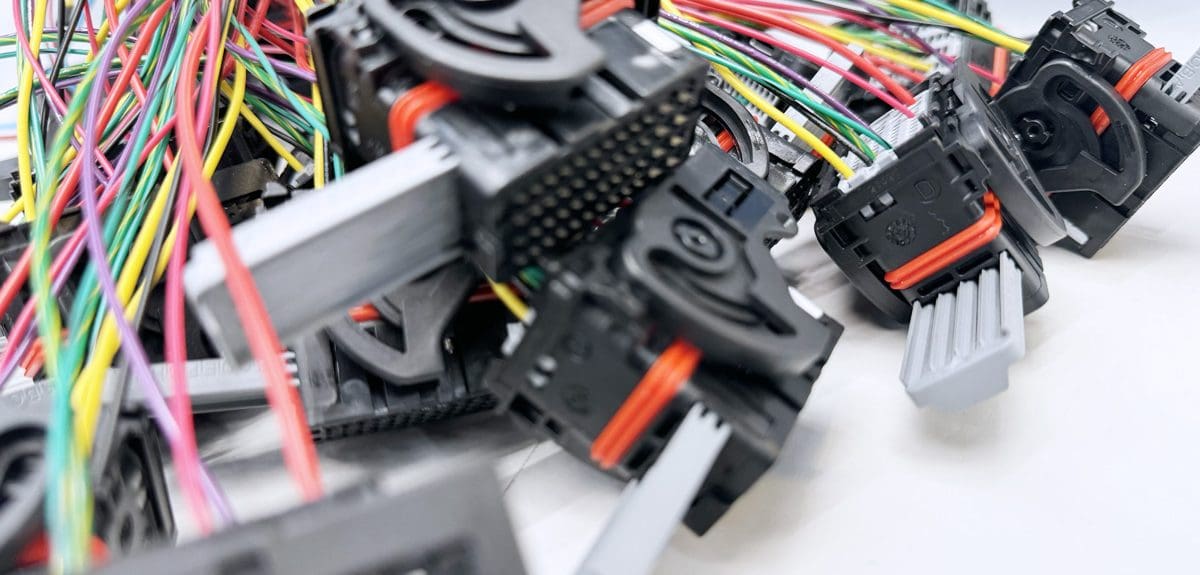 Batch of IoT cable assemblies on a factory work bench.
