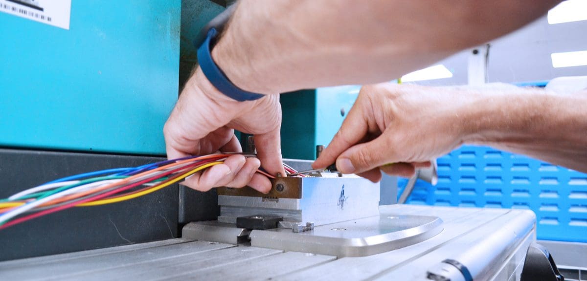 Cable assembly being positioned into a form ready for overmolding.